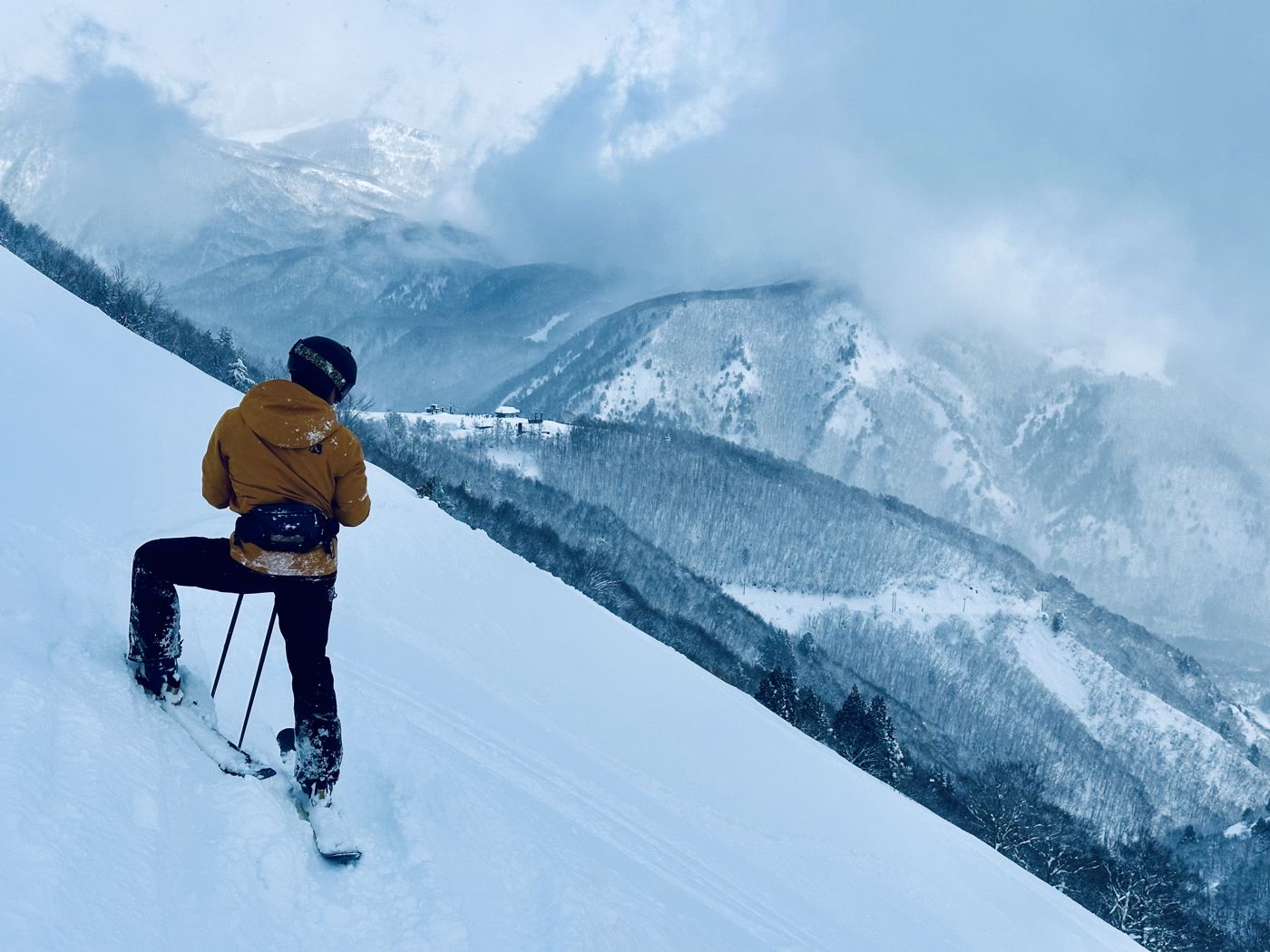 Brett Wheeless skiing high on a mountainside in the backcountry